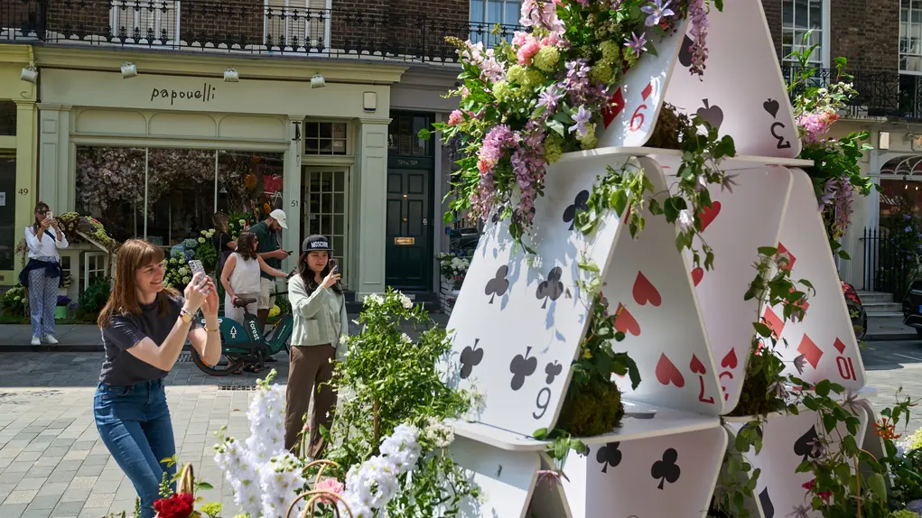 Playing cards arranged into a v shape and wrapped with flowers