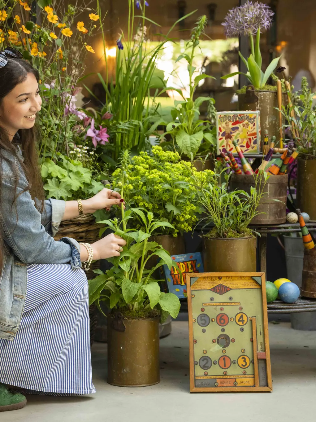 A woman kneels down to look at the Horatio's Garden flower display